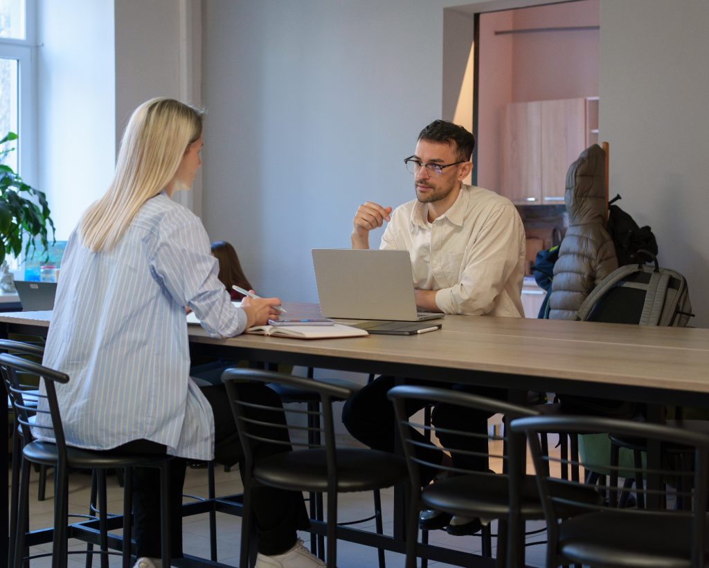 Two people in a meeting at a table.